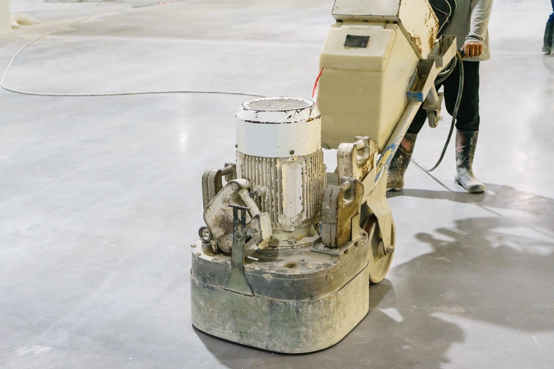 Women worker using polishing machine for smoothing surface to finish concrete slab.concrete floors